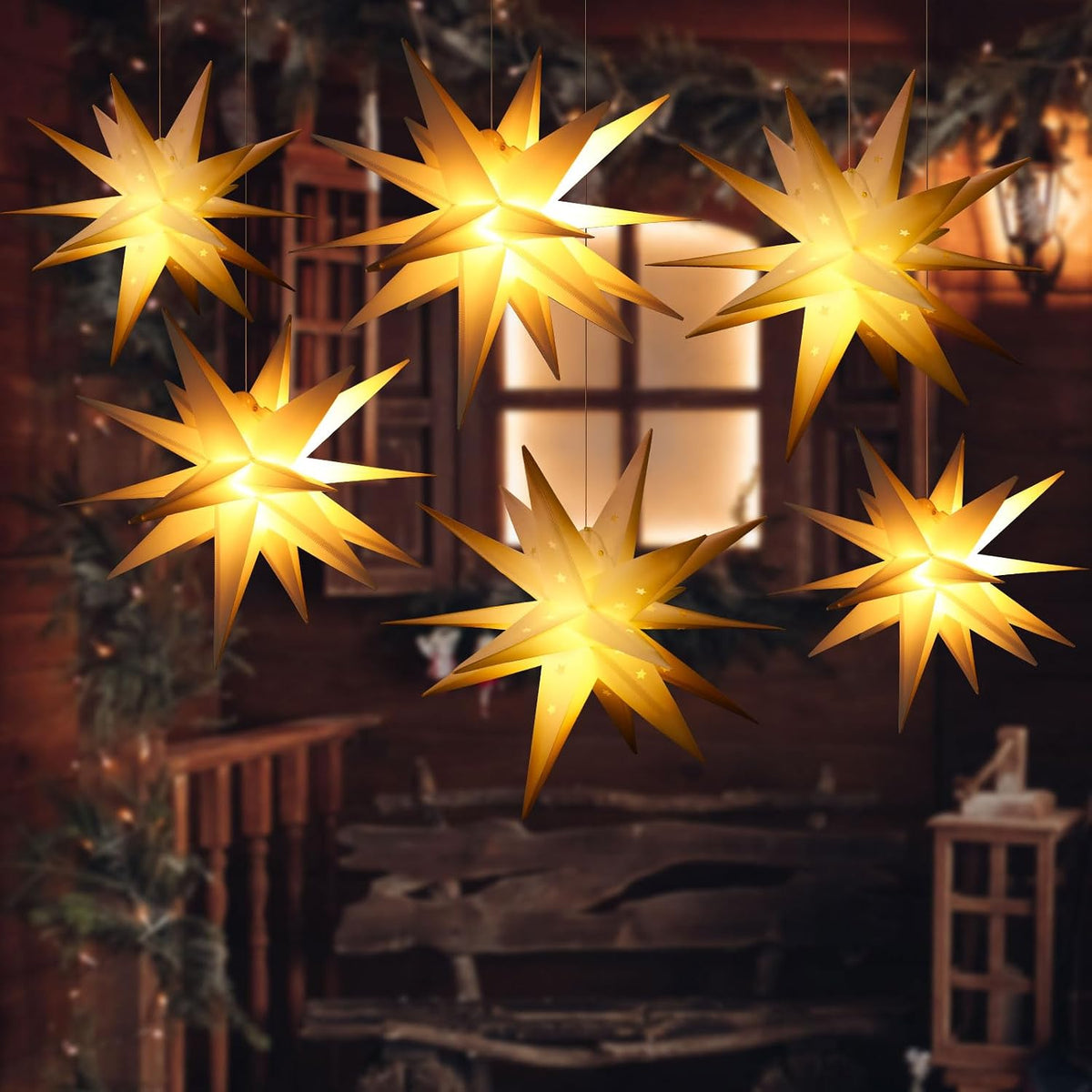 Several glowing warm white Moravian star lanterns hanging outside a window at night
