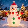 White snowman inflatable in a red knit hat and earmuffs winking in a snowy backyard