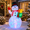 Snowman inflatable in a top hat holding a gift with a clear body glowing in rotating colored lights