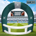 Green and white football helmet inflatable arch on a football field