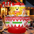 Gingerbread man in a Santa hat sitting in a red and white Hot Cocoa cup inflatable on a porch