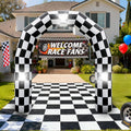 Black and white checkered inflatable arch with a tire at its base over a checkered path