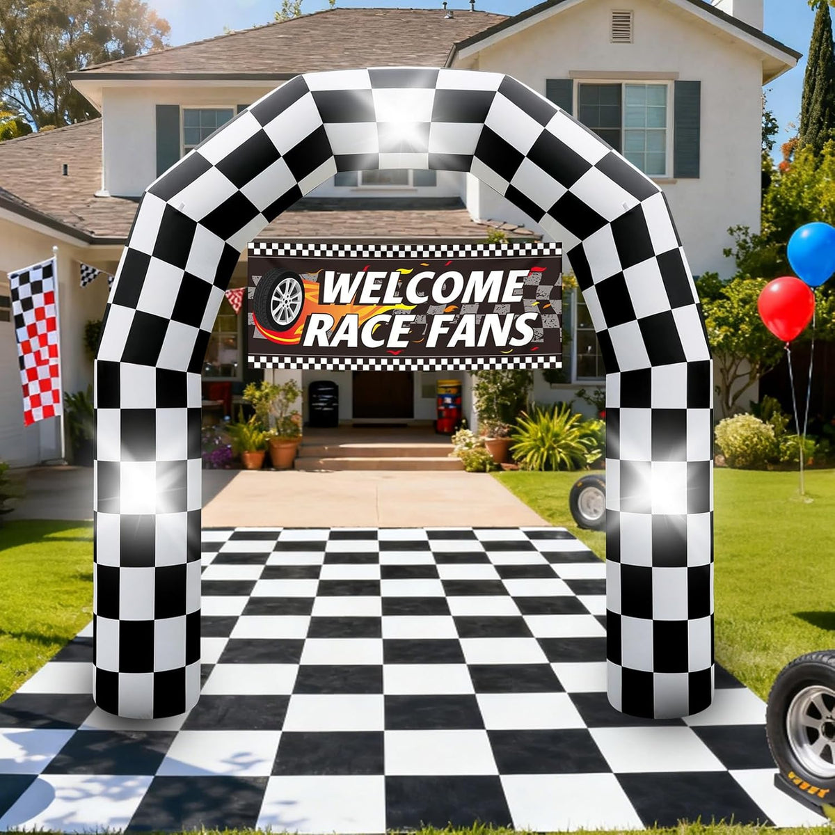 Black and white checkered inflatable arch with a tire at its base over a checkered path