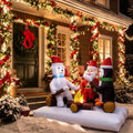 Santa, a polar bear and a penguin roasting marshmallows over a lit campfire inflatable by a front door
