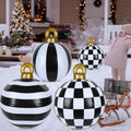 Black and white striped and checkered inflatable Christmas ornament balls on a snowy porch